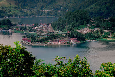 High angle view of river amidst trees and buildings