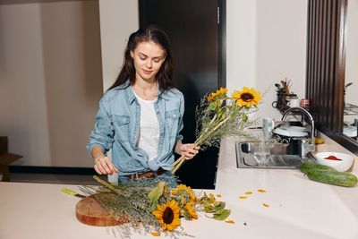 Portrait of young woman using mobile phone on table