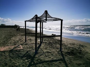 Lifeguard hut on beach against sky