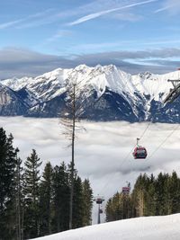 Overhead cable car over snowcapped mountains against sky