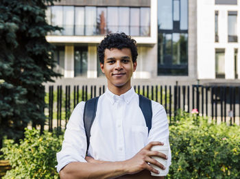Portrait of a smiling young man standing against building