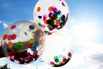 Low angle view of balloons balls against sky