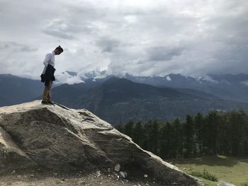 Man standing on rock against mountains