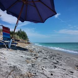 Scenic view of beach against cloudy sky