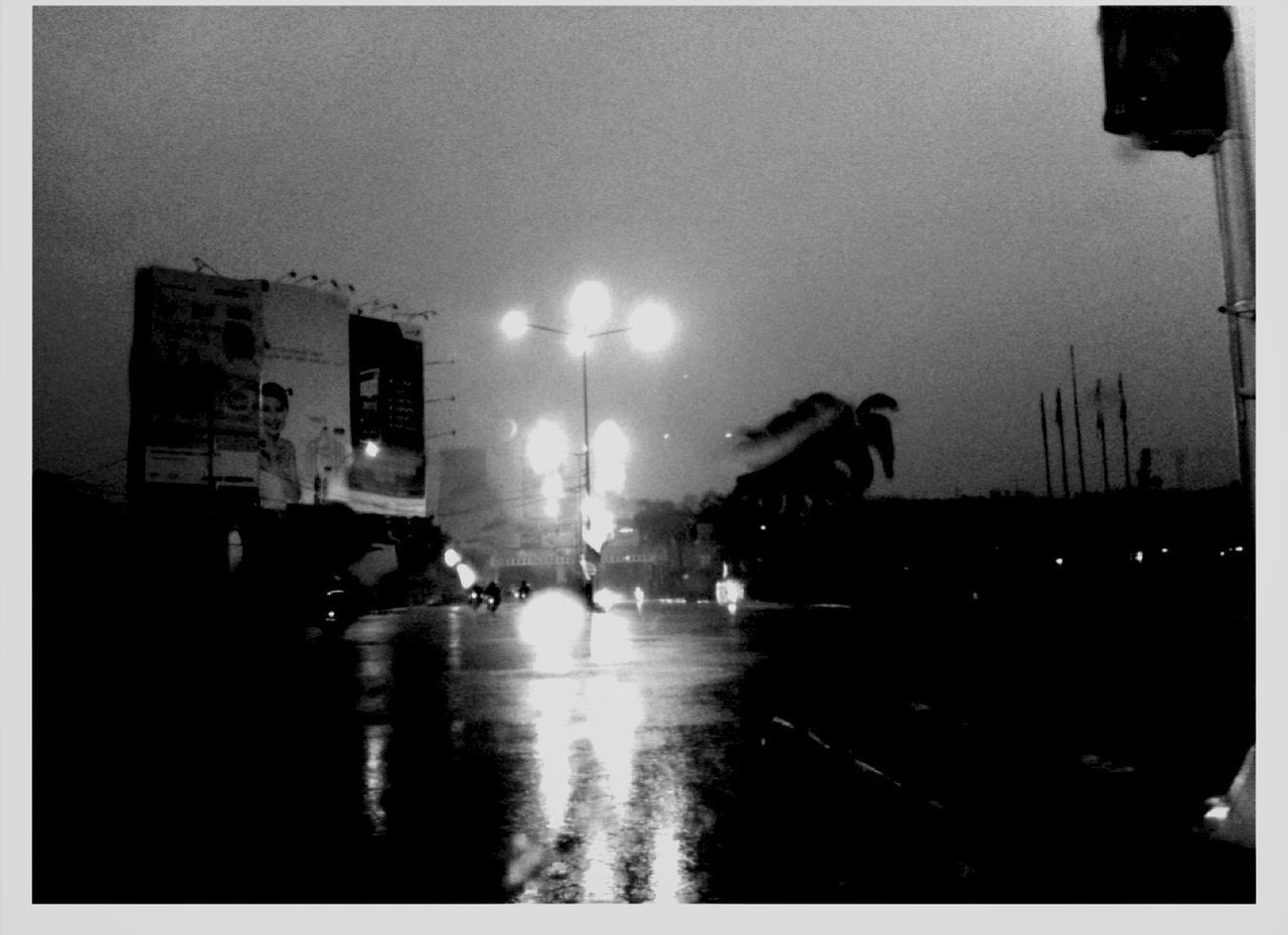 transfer print, illuminated, building exterior, transportation, architecture, built structure, night, street, auto post production filter, street light, city, mode of transport, city life, car, wet, rain, reflection, sky, land vehicle