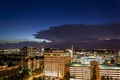 High angle view of illuminated buildings against sky at night