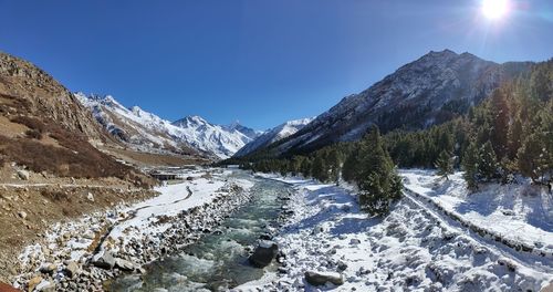 Scenic view of snowcapped mountains against clear blue sky