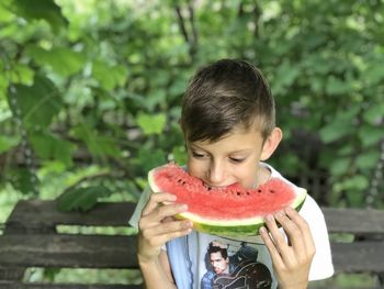 The boy enjoys the taste of ripe watermelon 