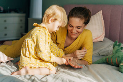 Mother and daughter on bed at home