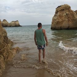 Full length rear view of man walking on beach