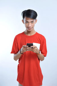 Potrait of young asian student playing a smartphone