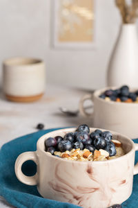 Close up of bowls with oatmeal porridge with blueberries for breakfast