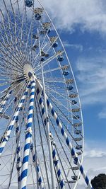 Low angle view of ferris wheel against blue sky