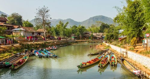 Boats moored in river against sky