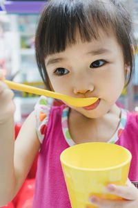 Close-up of cute girl having drink at home