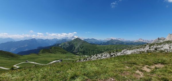 Scenic view of landscape and mountains against blue sky