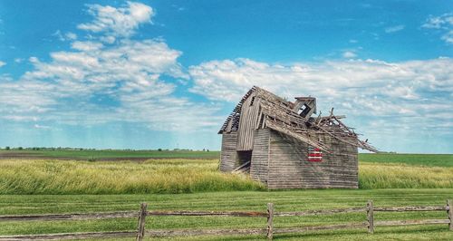 Traditional windmill on field against sky