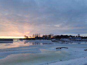 Scenic view of frozen sea against sky during sunset