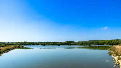 Scenic view of lake against blue sky