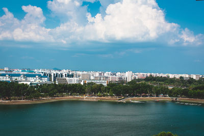 Buildings by sea against sky