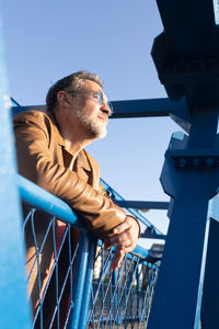 Man thinking and standing on bridge