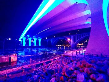 Illuminated bridge in city at night