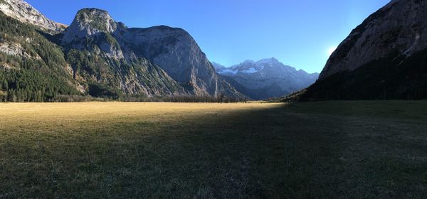 Scenic view of field by mountains