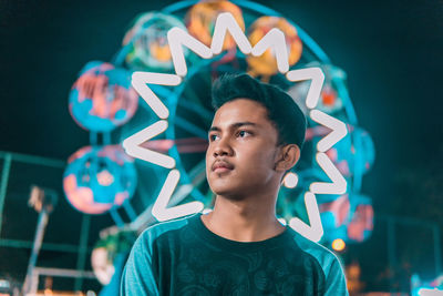 Portrait of teenage boy looking away at night