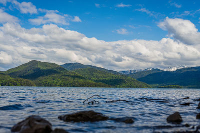 Scenic view of lake by mountains against sky