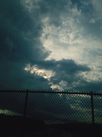 Chainlink fence against cloudy sky