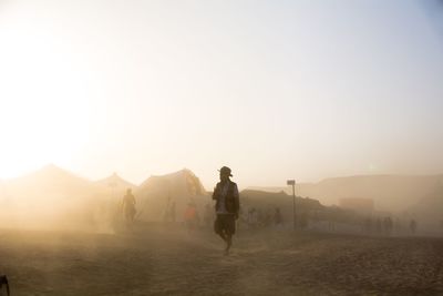 Full length of man walking on mountain against clear sky