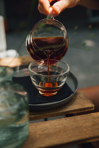 Close-up of person hand pouring glass