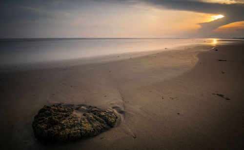 Scenic view of beach against sky during sunset