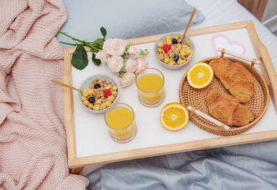 Romantic breakfast with croissants, orange juice and rose flowers.