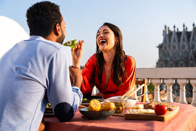 Portrait of smiling friends sitting on table