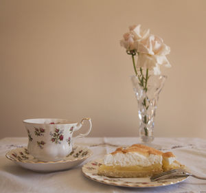 Flower vase on table against wall