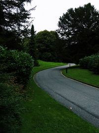 Road amidst trees against sky