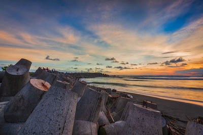 Stack of wave breakers on land against sky during sunset, glagah beach