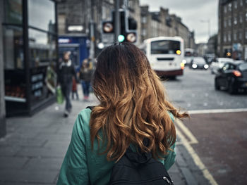 Rear view of woman walking on street in city