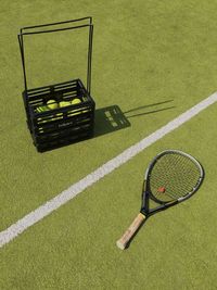 High angle view of tennis balls and racket on playing field