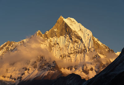 Scenic view of snowcapped mountains against clear sky