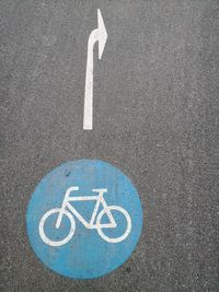 High angle view of arrow and bicycle signs on road