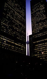 Low angle view of illuminated buildings against sky at night