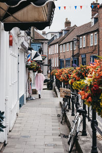 Rear view of people walking on street amidst buildings