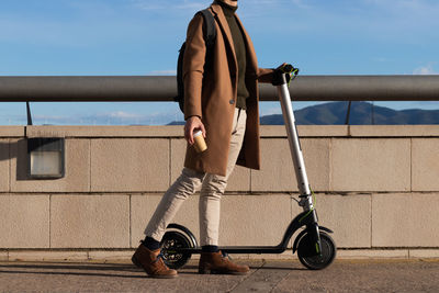 Unrecognizable young bussinesman using electric scooter as alternative, transport and eco friendly