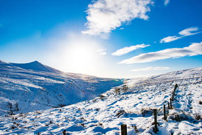 Scenic view of snowcapped mountains against blue sky