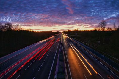 Light trails on highway at sunset