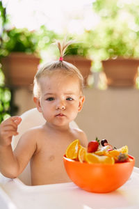 Portrait of happy boy with fruits in bowl