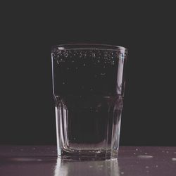 Close-up of beer glass against black background