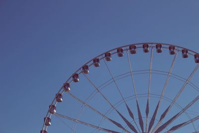 Low angle view of ferris wheel against clear blue sky